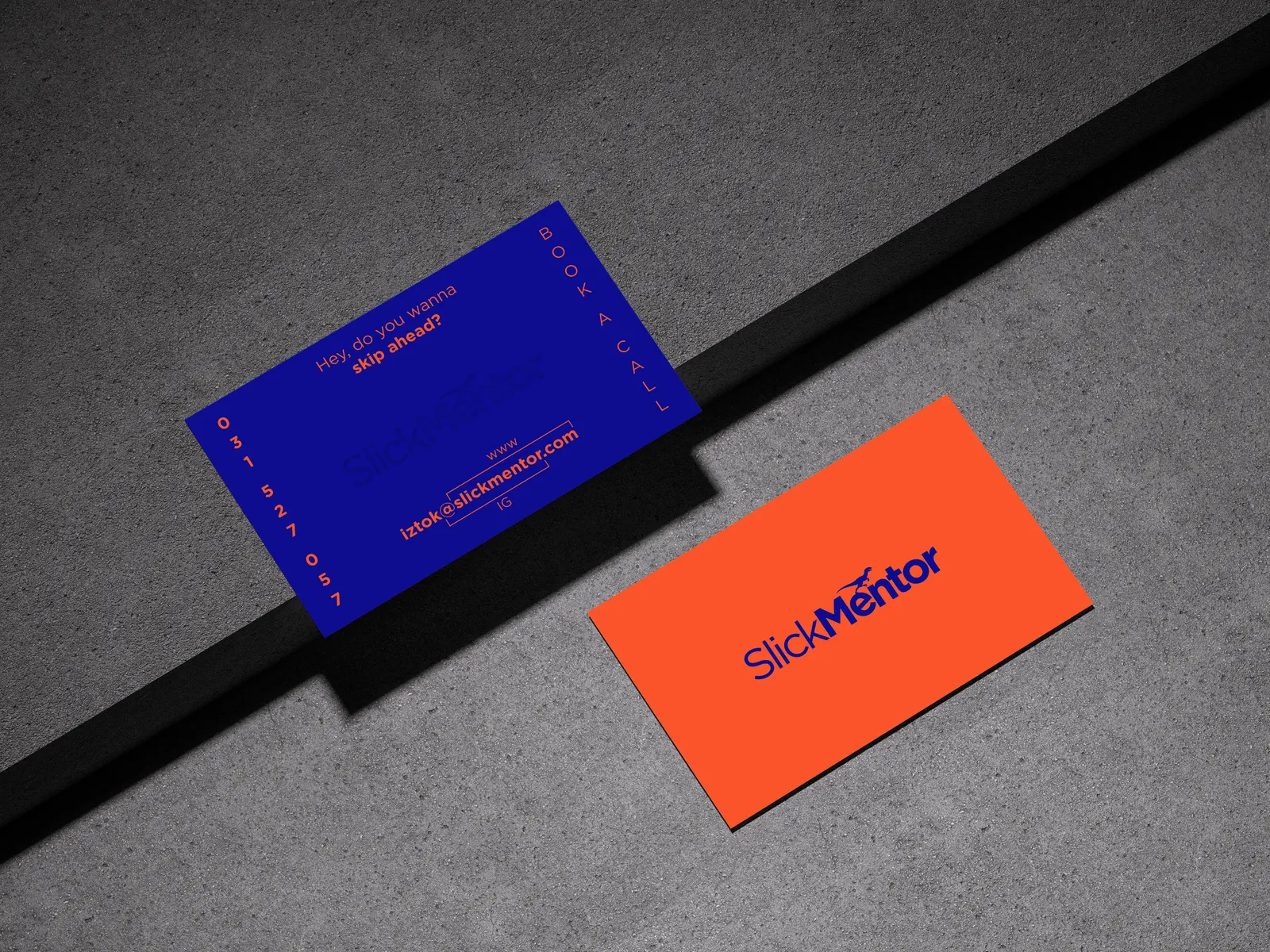 SlickMentor business cards mockup, bold blue and orange cards on grey concrete