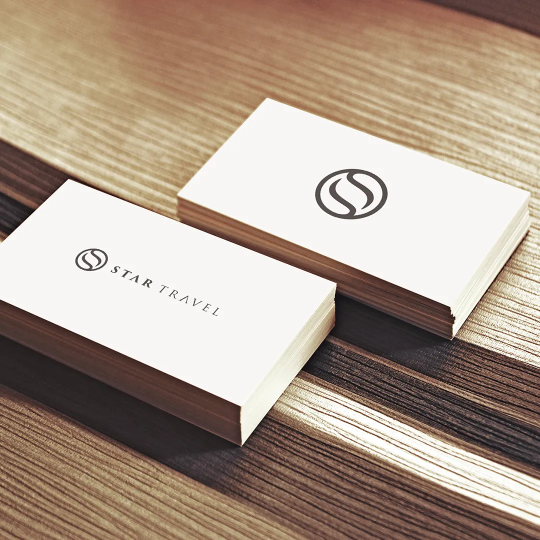 Star Travel business cards on wood with an elegant grey S monogram and serif wordmark