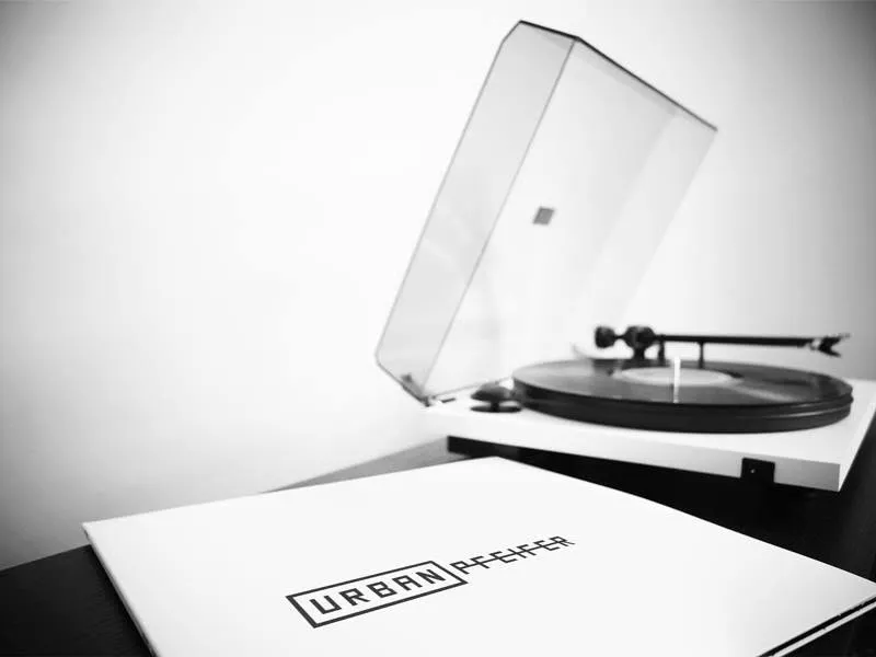 Urban Pfeifer record sleeve beside a turntable, black-and-white minimalist branding